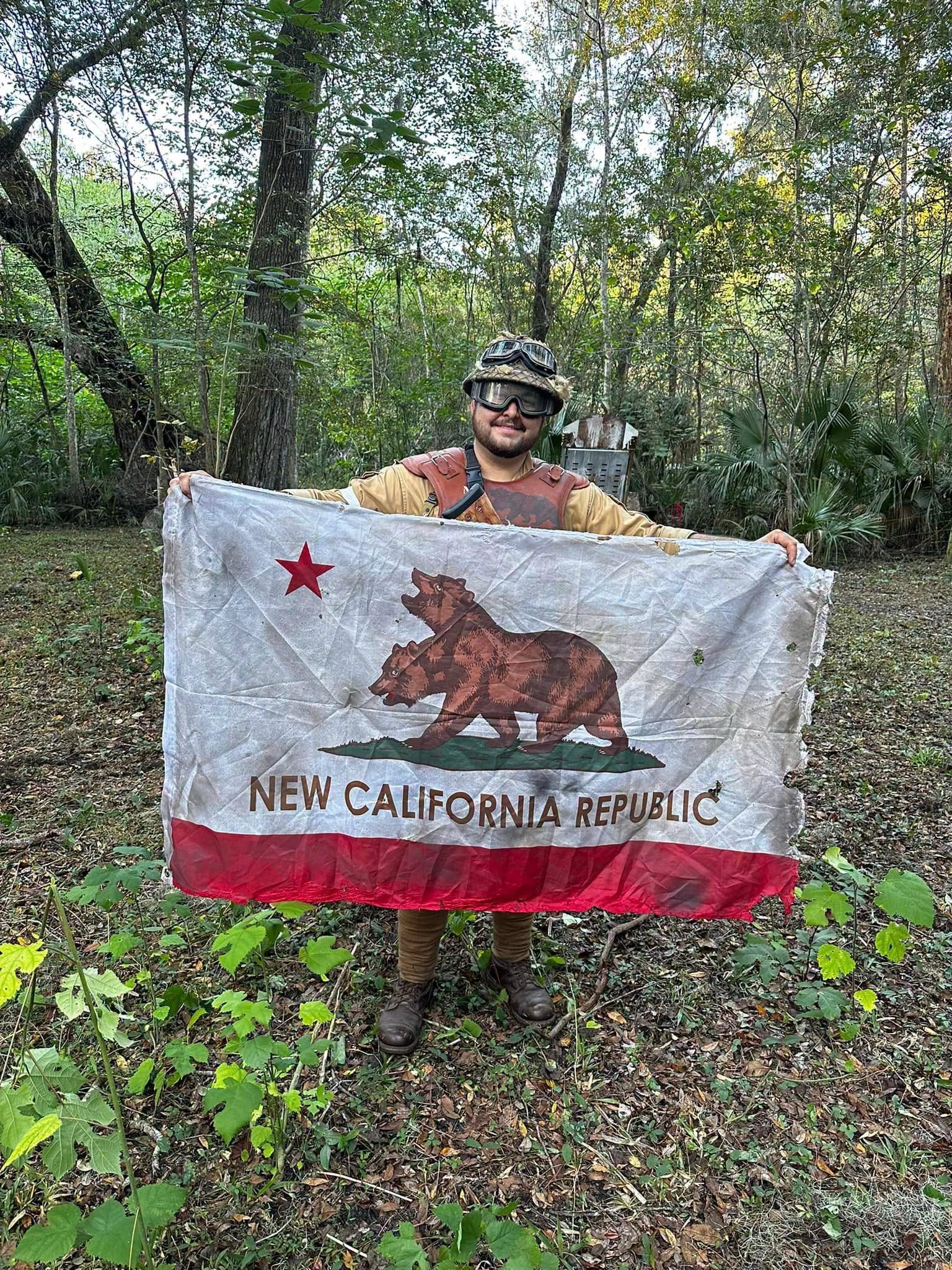 NCR trooper holding the New California Republic flag at a MindGame Productions event