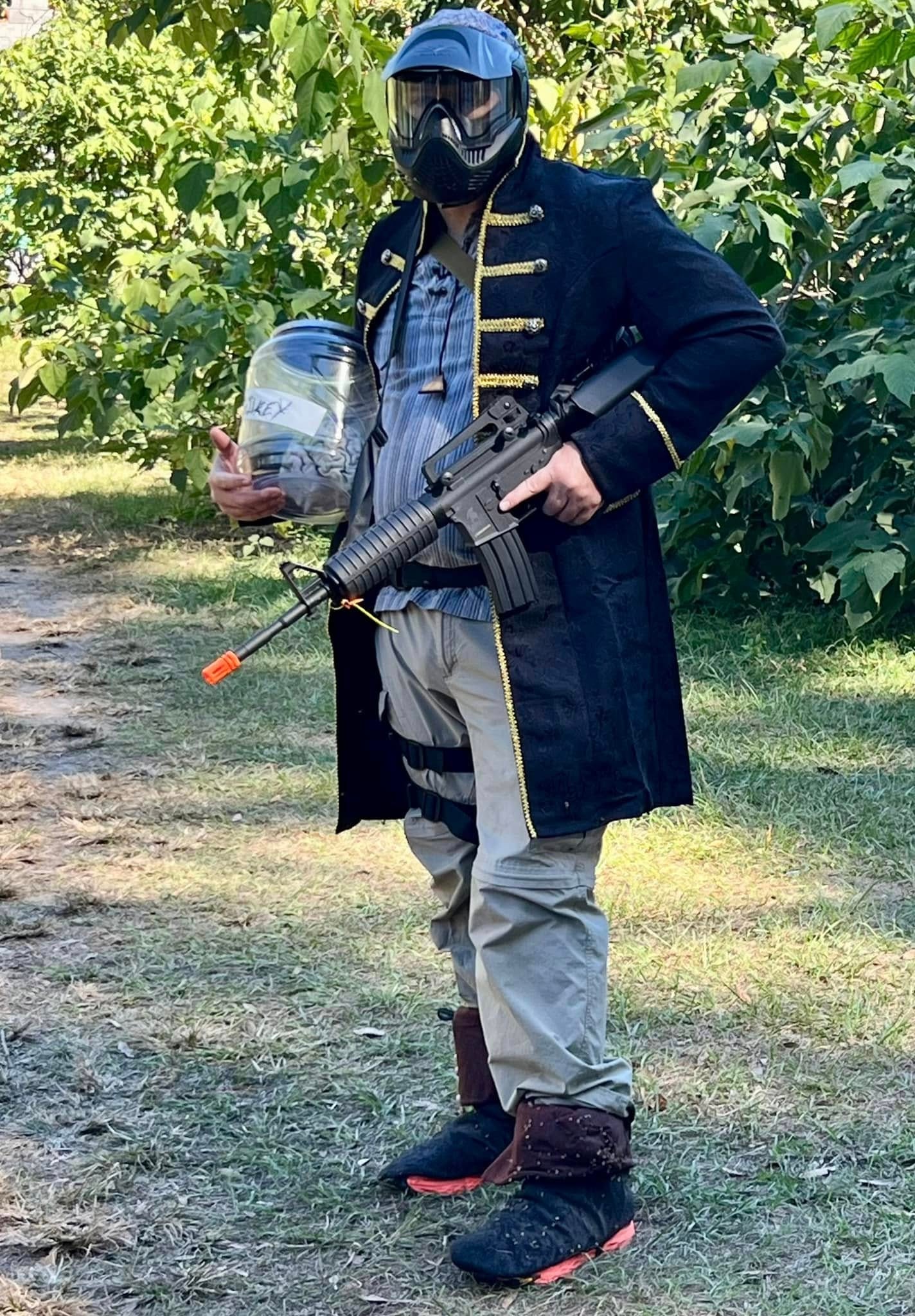 Ravager in a black military coat with airsoft rifle at a MindGame Productions event