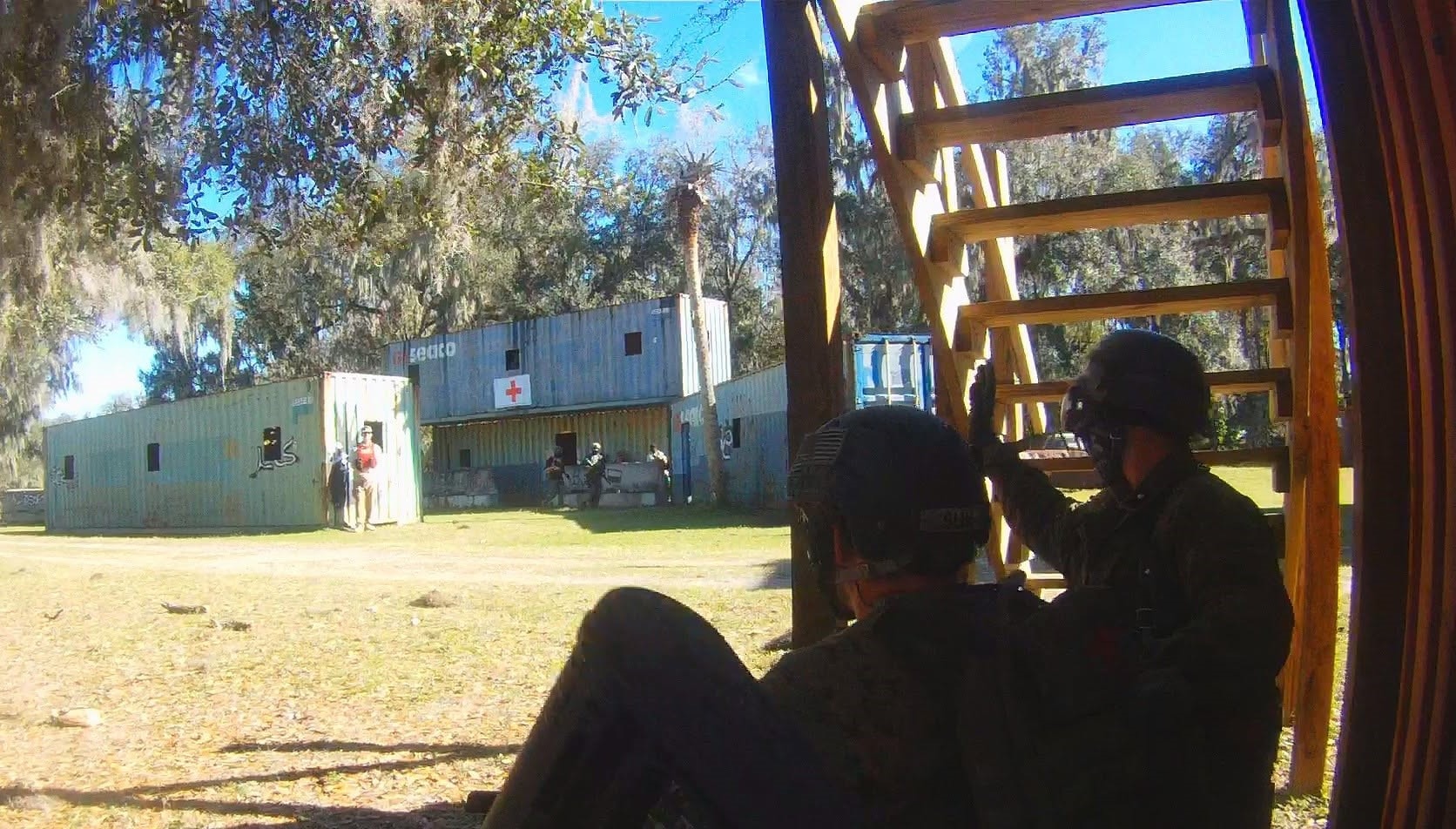 Two players in overwatch position covering the medic station containers at Amerika