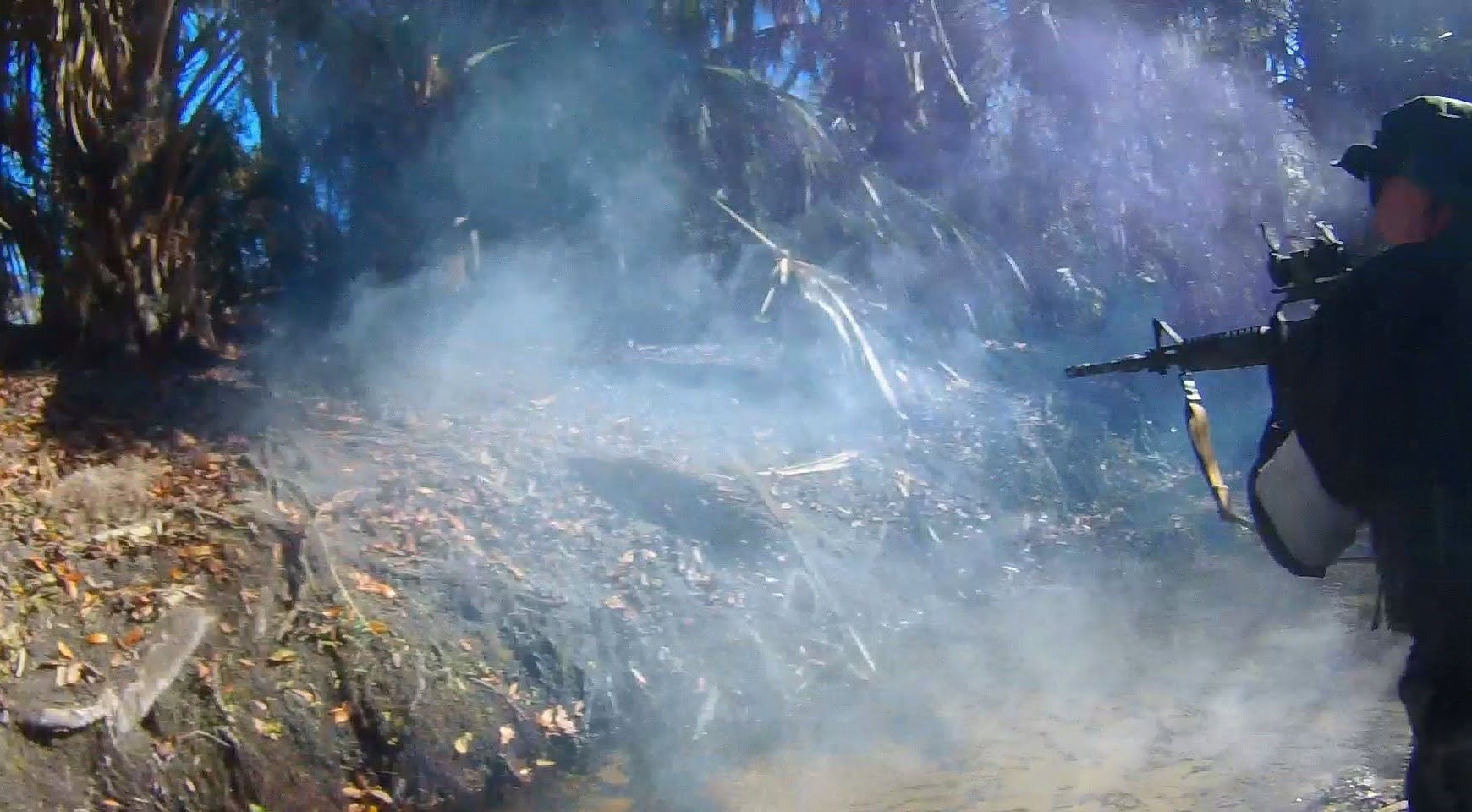 Player firing rifle through a smoke cloud in the forest at Amerika