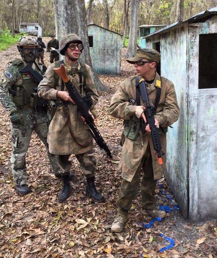 Three players in WWII-era German and resistance gear advancing through the field
