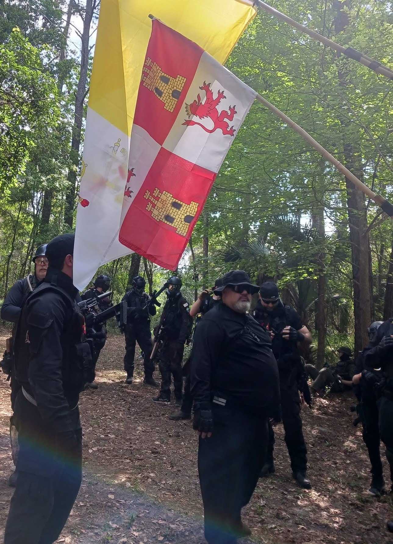 Players marching under the Spanish colonial flag in the forest