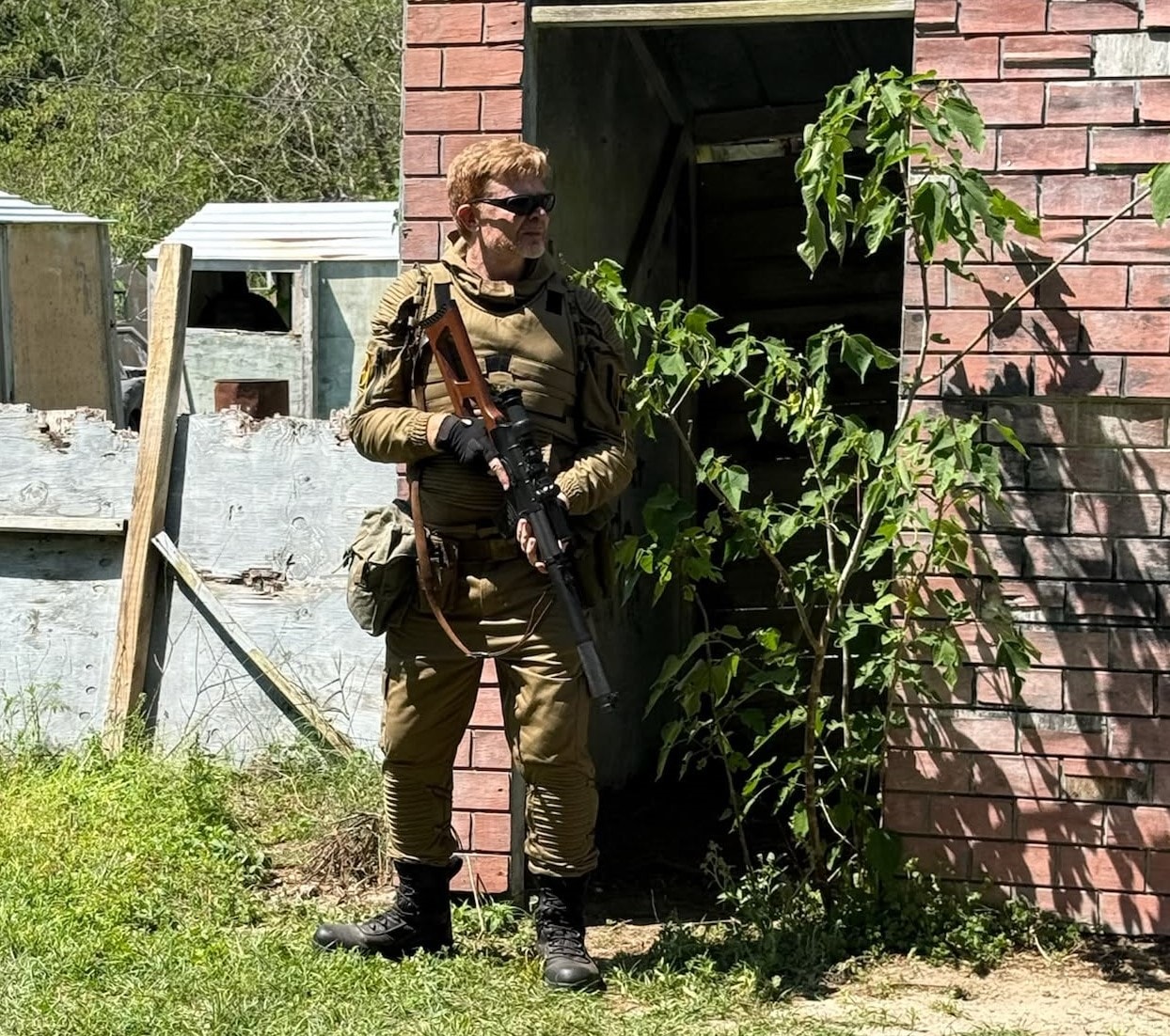 Zone player in tactical gear at an abandoned brick building