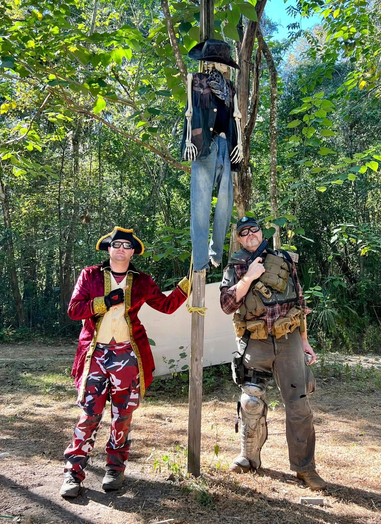 Two costumed players posing with skeleton prop