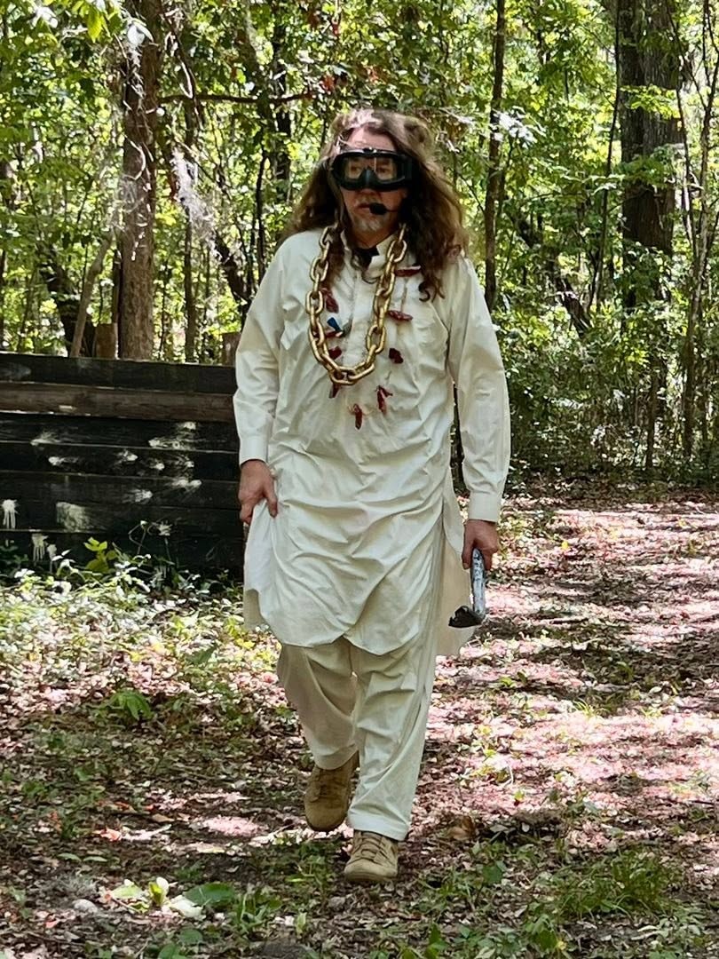 Robed player walking forest path at Wasteland