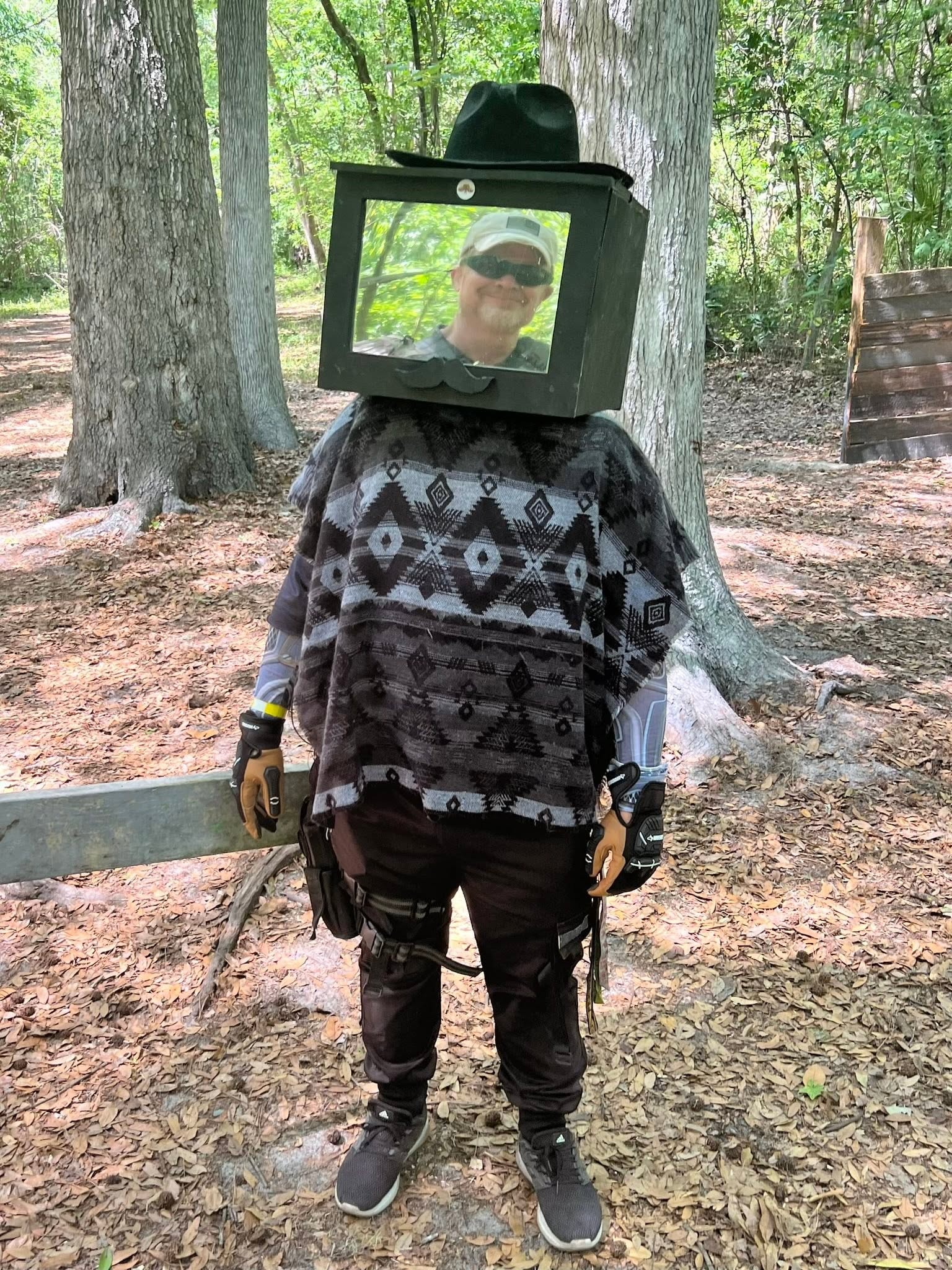 Player with TV monitor head costume in forest