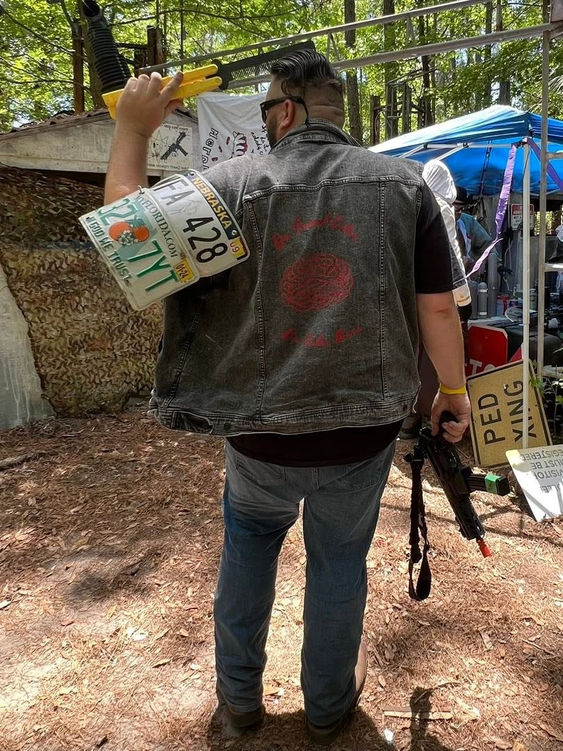 Player holding license plates and airsoft gun