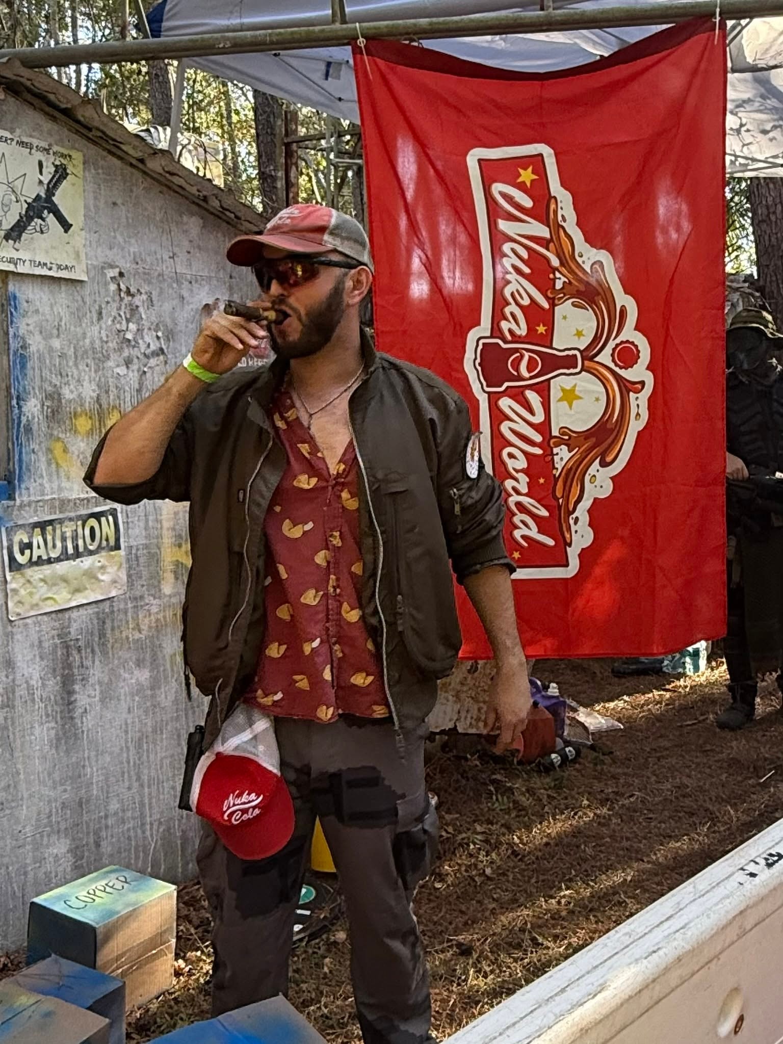 Man smoking cigar at Nuka Cola banner backdrop