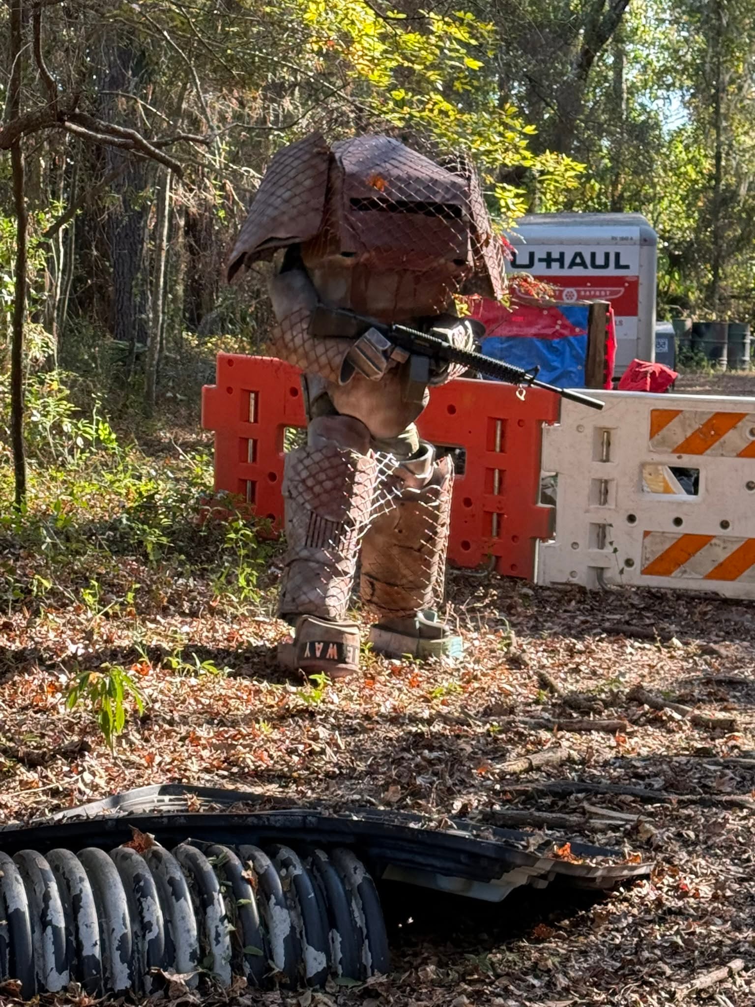 Metal dinosaur sculpture holding rifle