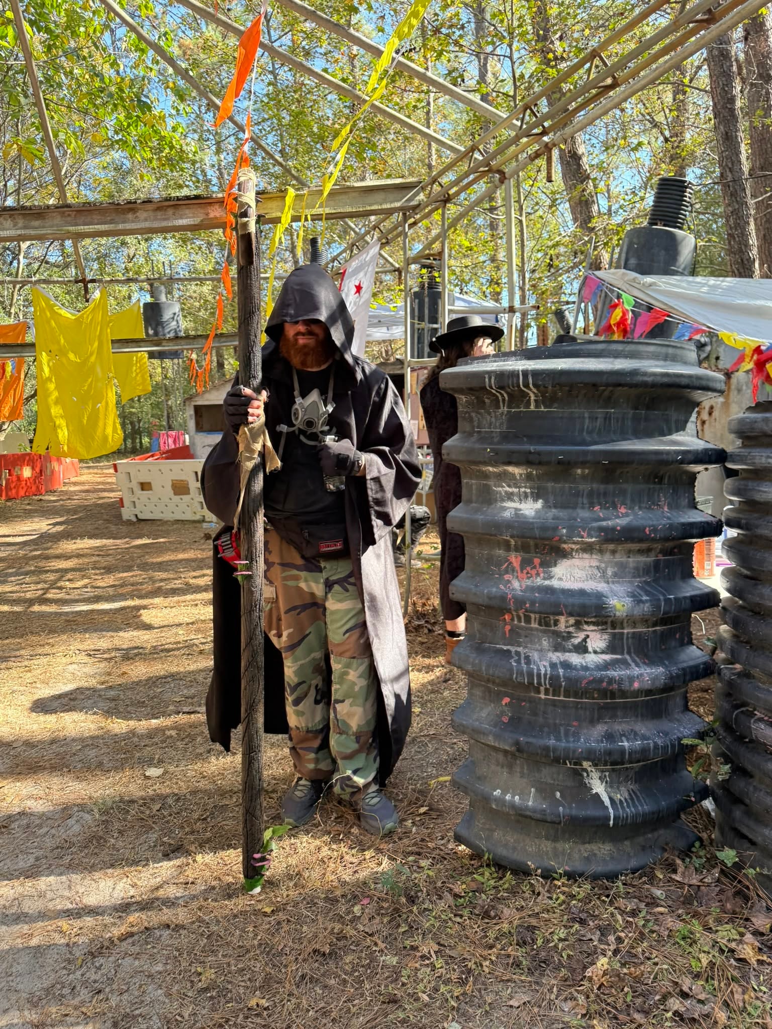 Hooded dark robed player with staff at event field