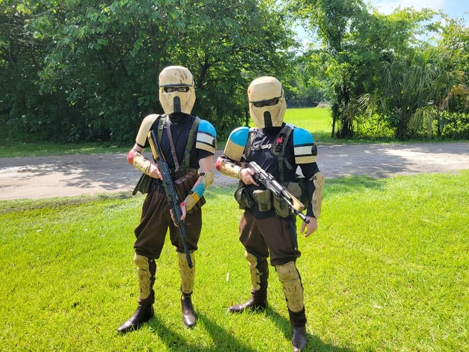 Costumed characters posing with toy blasters outdoors