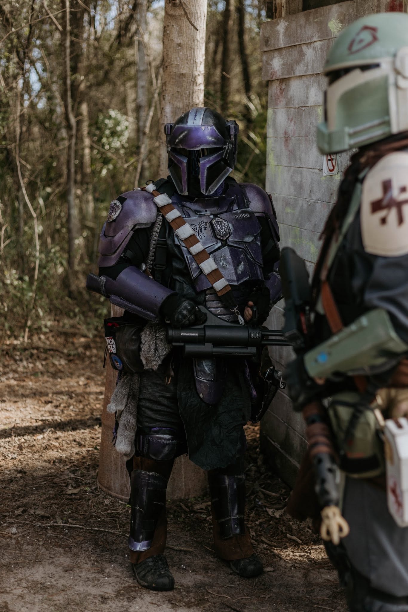Armored Mandalorian warrior confronting soldier in forest alley